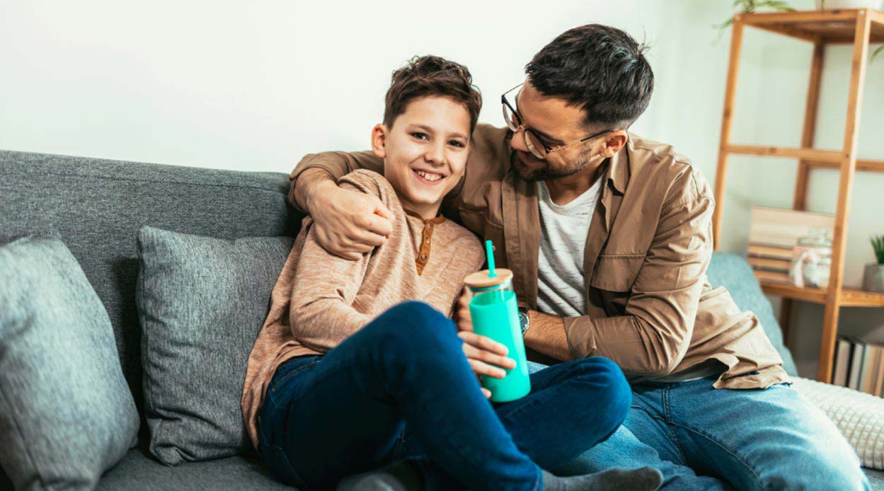 father and son sitting on settee